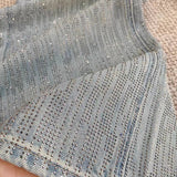 Vaqueros de pierna ancha y descoloridos, completamente adornados con pedrería.