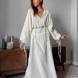 Vestido largo de algodón con aberturas y cintura anudada, manga larga.