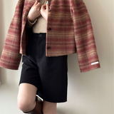Chaqueta de lana a cuadros, cuello redondo, botonadura sencilla, hombros caídos.