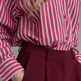 Blusa británica distintiva con rayas rojas y mangas largas.