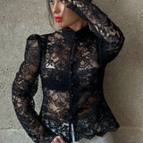 Elegante blusa con mangas abullonadas en encaje y cuello alto.