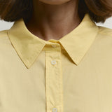 Blusa holgada de algodón amarilla con botones, ideal para uso diario.