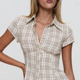 Blusa corta de cuadros, cintura ajustada, escote en pico y botones en la parte delantera.