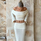 Conjunto sexy de dos piezas compuesto por un top corto con hombros descubiertos y una falda de talle alto y color liso.
