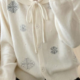 Un chaleco con cuello lavallière adornado con perlas y copos de nieve.