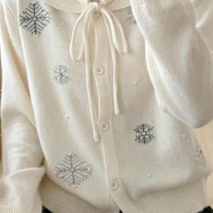 Un chaleco con cuello lavallière adornado con perlas y copos de nieve.