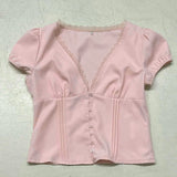 Blusa con aplicaciones de encaje, escote en pico y mangas abullonadas.