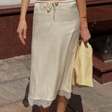 Elegante falda midi con ribete de encaje y cintura con lazo.