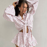 Conjunto de dos piezas: camisa de manga larga con cuello floral, pantalón corto con volantes.