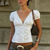 Blusa con aplicaciones de encaje, escote en pico y mangas abullonadas.