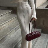 Elegante vestido largo ajustado de punto con cuello redondo, mangas acampanadas y abertura transparente.