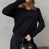 Blusa holgada con cuello polo jacquard y mangas largas.