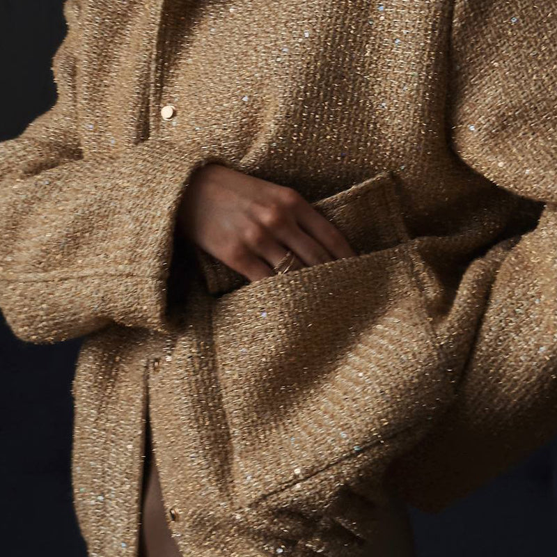 Chaqueta de lentejuelas con cuello alto y bolsillos.