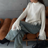 Blusa de punto asimétrica con flecos y cuello redondo