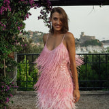 Vestido de noche con tirantes finos y lentejuelas, adornado con plumas.
