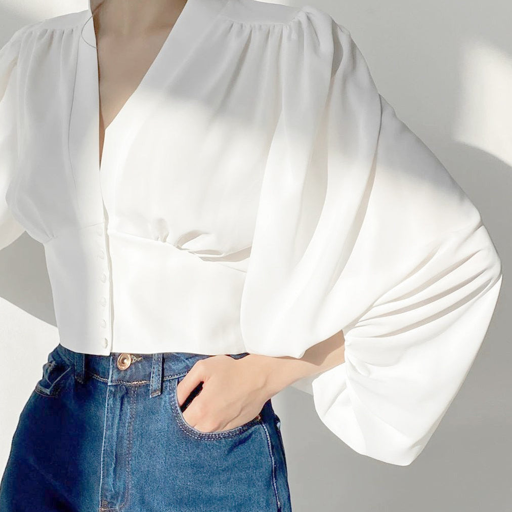 Blusa vintage con mangas farol, escote en pico y corte entallado.