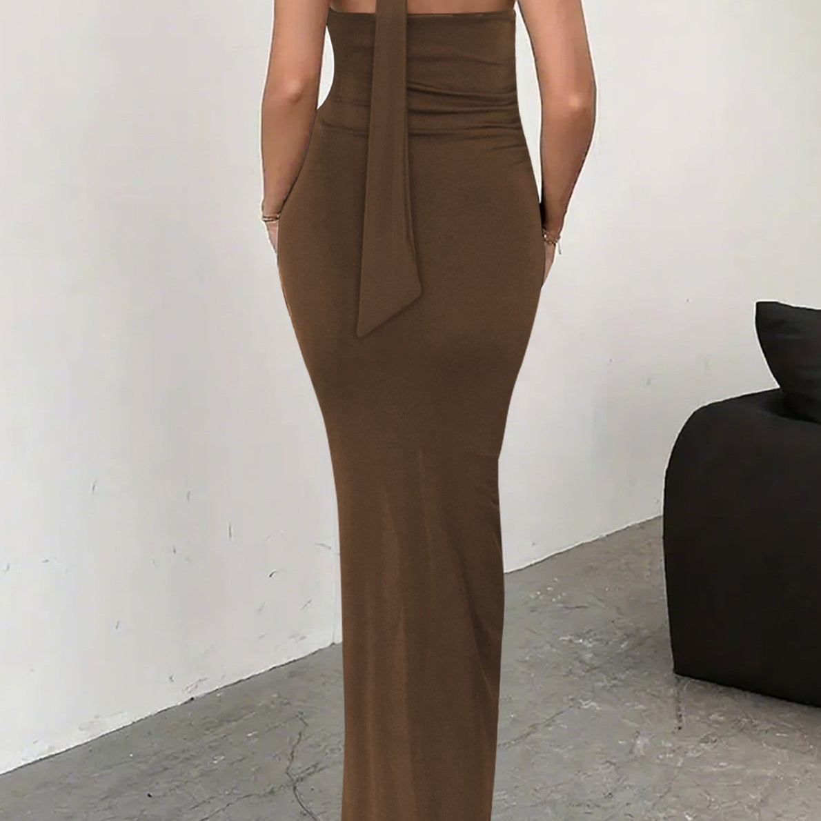 Vestido de noche sin espalda con detalle de lazo y abertura alta.