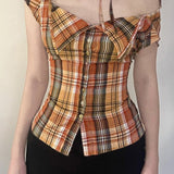 Blusa corta de cuadros, cintura ajustada, cuello con lazo y botones en la parte delantera.