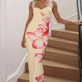Vestido largo con estampado floral, espalda abierta y paneles de encaje, diseño con hombros descubiertos.