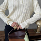 Blusa holgada con cuello polo jacquard y mangas largas.