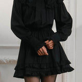 Elegante mini vestido de manga larga y encaje, adornado con lazo, corte trapecio.
