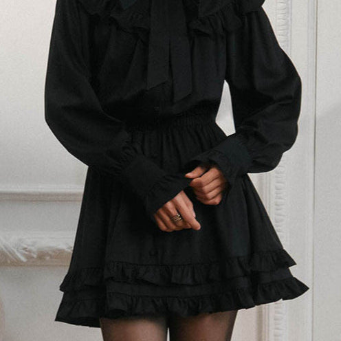 Elegante mini vestido de manga larga y encaje, adornado con lazo, corte trapecio.