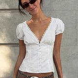 Blusa con aplicaciones de encaje, escote en pico y mangas abullonadas.