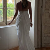 Vestido largo de tul con amplio escote en pico y volantes, espalda abierta y escote en pico.