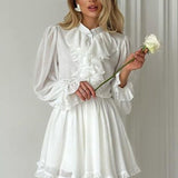 Elegante minivestido de manga larga y escote alto con volantes.