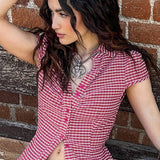 Blusa entallada con estampado de cuadros preppy y cuello abotonado.