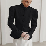Elegante blazer de cuello alto y mangas abullonadas, inspirado en el diseño francés.