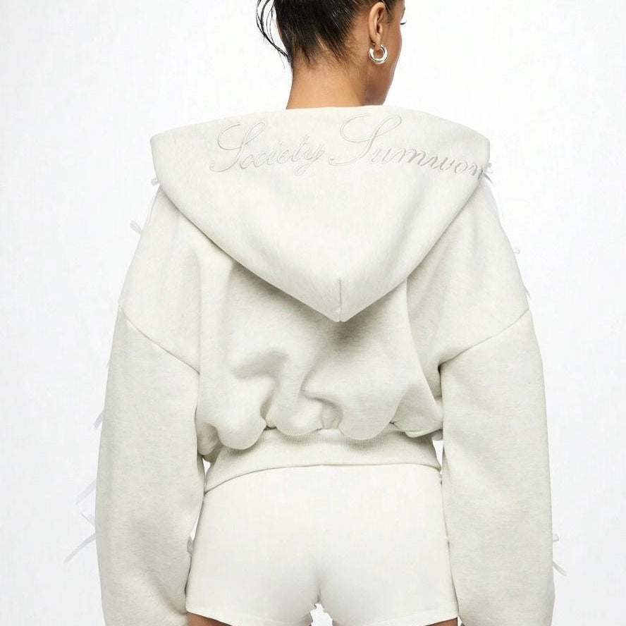 Sudadera con capucha y cremallera con lazo lateral bordado