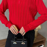 Blusa holgada con cuello polo jacquard y mangas largas.
