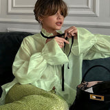 Blusa elegante y sexy con mangas acampanadas transparentes.