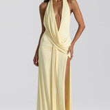 Vestido largo, sencillo, sin espalda, con escote pronunciado y abertura hasta el suelo.