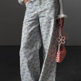 Vaqueros azul claro con estampado floral, cintura alta y pierna ancha.