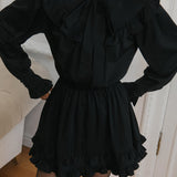 Elegante mini vestido de manga larga y encaje, adornado con lazo, corte trapecio.