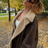 Chaqueta larga de piel sintética con múltiples cremalleras.