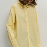 Blusa holgada de algodón amarilla con botones, ideal para uso diario.