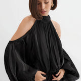 Blusa de manga larga y hombros descubiertos con un diseño único.