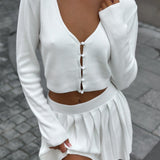 Conjunto sexy de dos piezas compuesto por un top corto de malla y una falda.