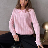 Blusa holgada con cuello polo jacquard y mangas largas.