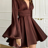 Vestido corto entallado de manga larga y escote en pico con lazo.