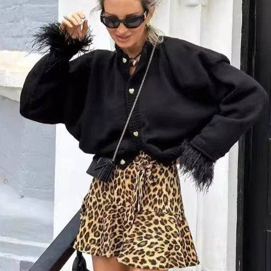 Elegante cárdigan con ribete de plumas