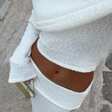 Conjunto sexy de dos piezas compuesto por un top corto con hombros descubiertos y una falda de talle alto y color liso.