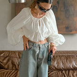 Elegante blusa con cintura elástica y cuello redondo, con cordón.