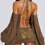 Vestido mini ajustado con espalda abierta, mangas murciélago y cadena.