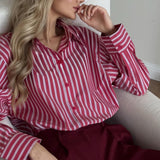 Blusa británica distintiva con rayas rojas y mangas largas.
