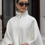 Elegante capa corta con cuello alto sencillo.