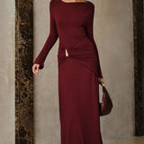 Vestido largo ajustado con cintura ceñida y fruncida y detalles metálicos.